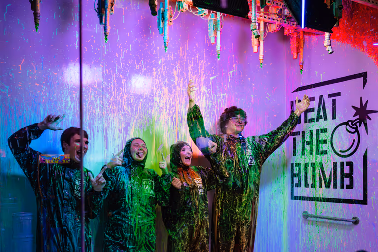 Team cheering under a slime shower after beating the bomb