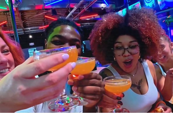 Friends toasting with cocktails at The Bomb Bar